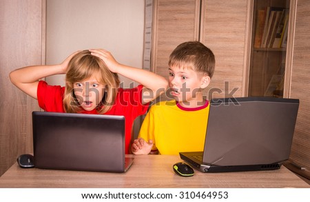 Girl having a computer problem. Cute children using laptops at home.