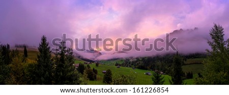 purple fog hanging over a mountain landscape in Switzerland, panorama