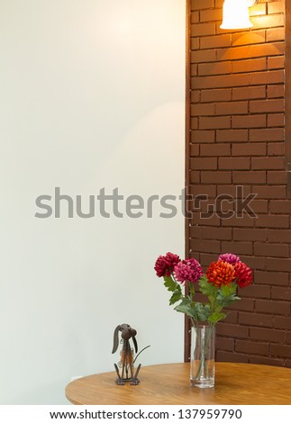 Vase with  flowers on the table and brick wall backgound