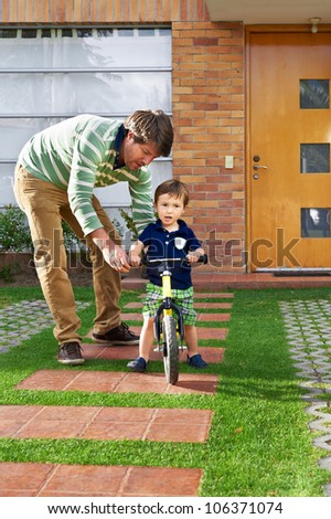 Father and son moment: Father teaching his son how to ride a bike