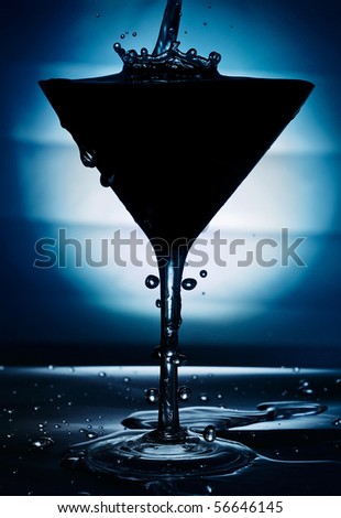 Pouring cocktail into elegant cup with back lighting