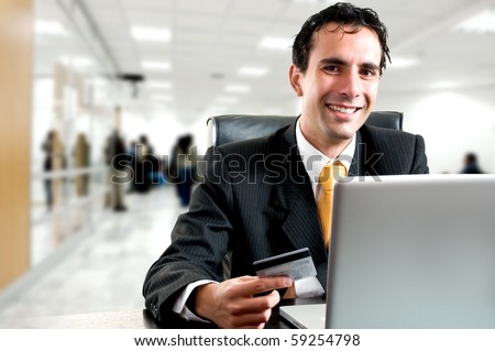 e-commerce concept: business man paying online with his credit card at office