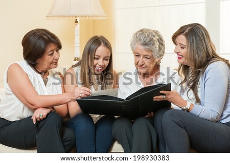 Women watching family album at home