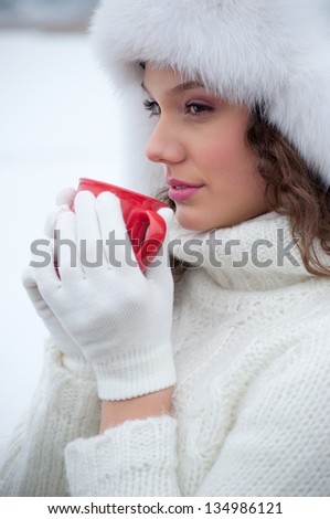 Beautiful girl drinking hot tea in cold winter