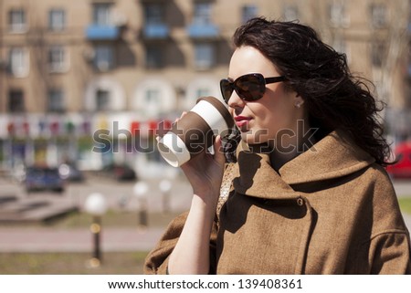 Girl with a coffee on the street.