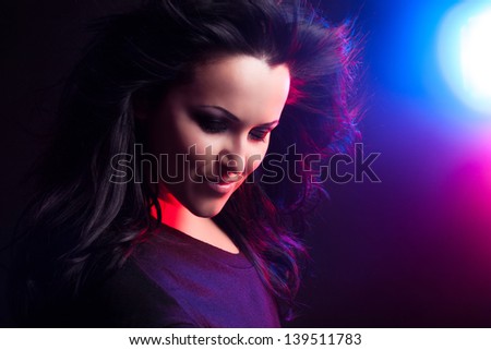 Beautiful young girl with fluttering hair on a bright background