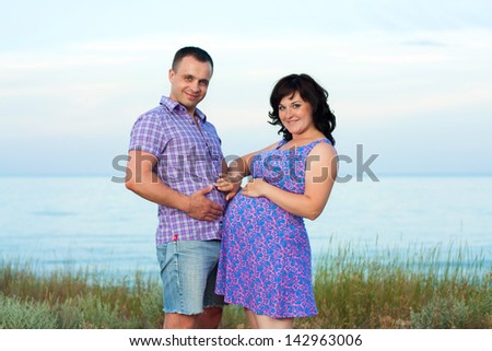 Pregnancy. Young loving couple on the beach. Happy family.