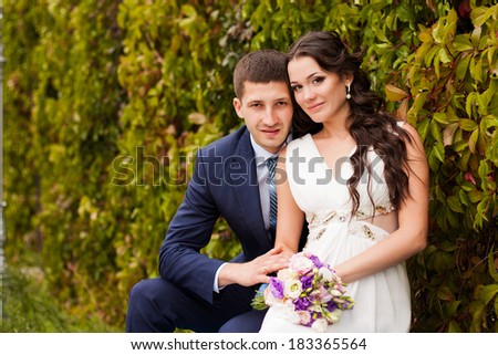 Happy newlyweds in park. Portrait of loving young bride and groom.