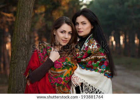 Beautiful Russian village girls in headscarves on the shoulders with apples in a dense forest