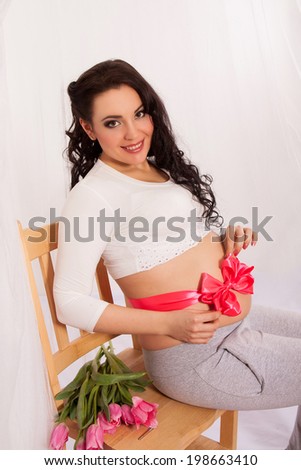 Beautiful pregnant woman with tulips. Happy pregnancy.