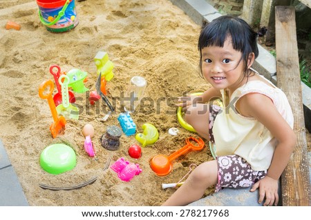 asian little girl play in a sand tray