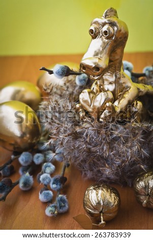Easter composition with golden eggs, nuts and dragon