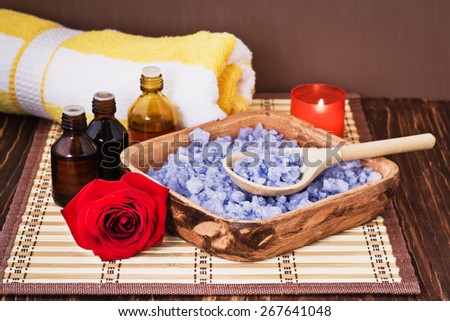 Composition with sea salt, stones, towel, infusion of herbs, candles and flower