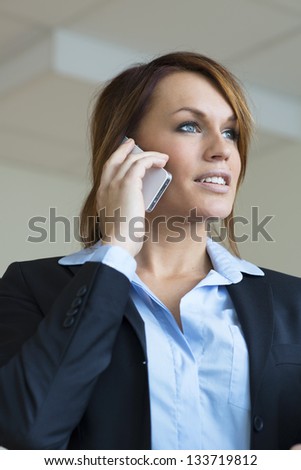 Young business woman in navy blue business suit, talking on his cell phone.