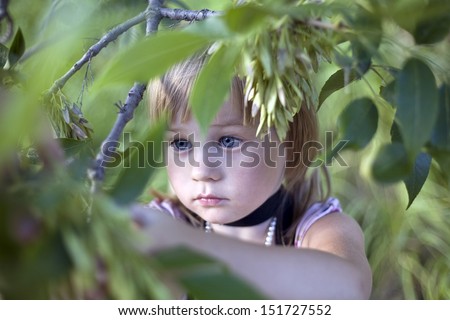 innocent child\'s face among leaves