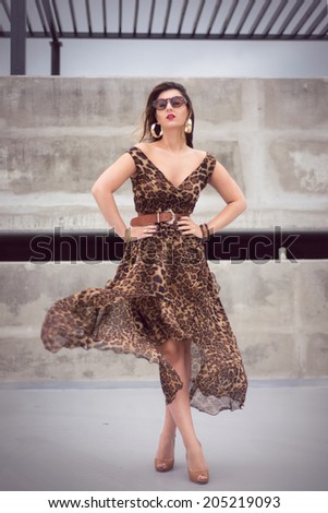Wild woman wearing an animal print outfit fluid dress in urban concrete jungle