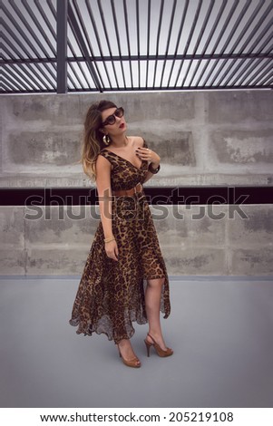 Wild woman in animal print outfit maxi dress in urban concrete jungle
