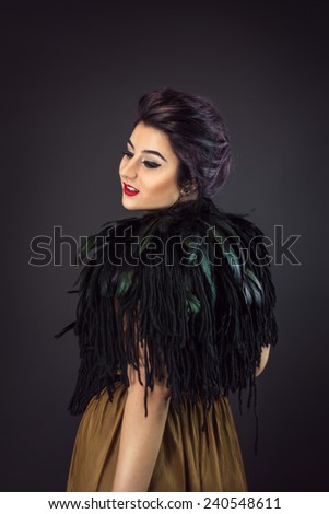 Portrait of Happy fashion woman dressed in a gold dress and feathers collar. New Year\'s Eve Party