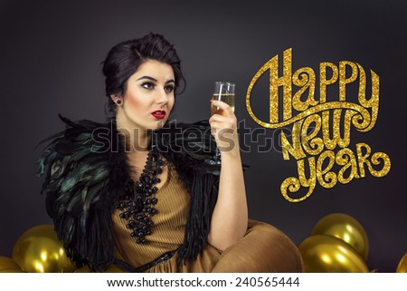 Fashion woman sitting ,drinking champagne, dressed in a gold dress and feathers collar, surrounded with yellow balloons . Happy new year copy text on the left