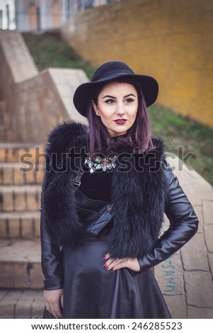 Stylish fashion Woman in trendy black leather and fur clothes. Turtle neck blouse and fedora hat