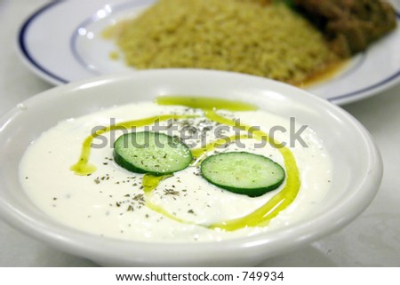 Milk curd yogurt dish with cucumber slices and olive oil with main course