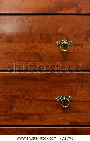 A section of rubber-wood drawers with dark reddish varnish and antique ring-pull handle