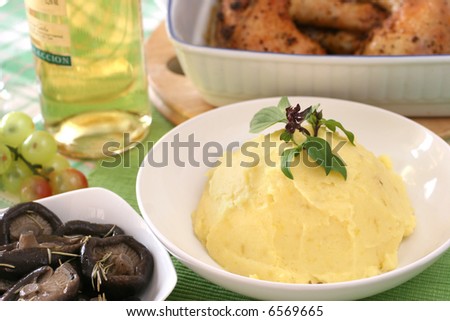 Mash potato with basil heaped up and smoothed off in a white ceramic bowl