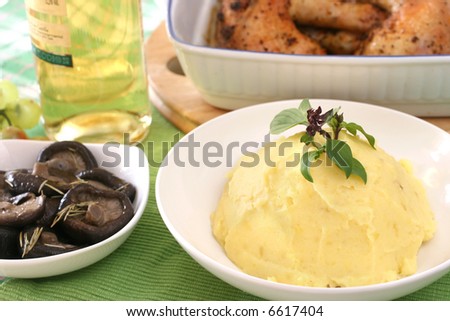 Mash potato with basil heaped up and smoothed off in a white ceramic bowl