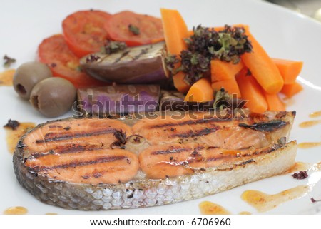 Pan seared salmon served with brinjal, carrots, sliced tomatoes and white wine