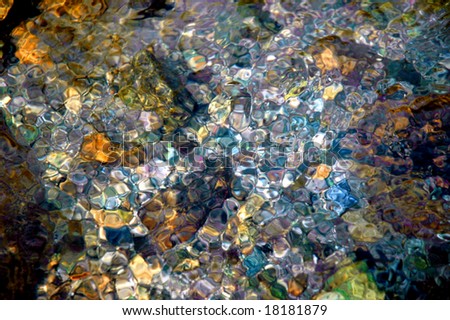 colorful bubbles on surface of water in mountain spring