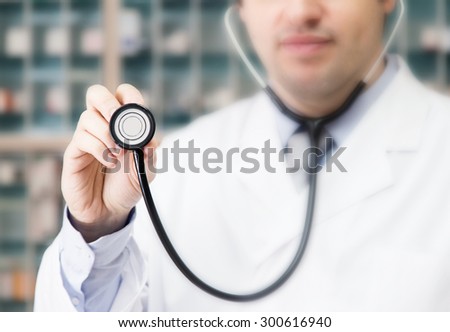 A doctor with a stethoscope. medicine cabinet in the background.