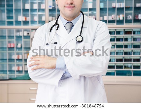 A medical doctor standing in front of the medicine cabinet. hospital clinic image. confident professional.
