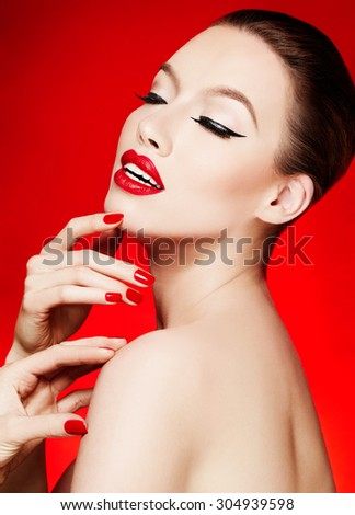 Beauty cosmetic image. Red lipstick and manicured nails isolated on red background.