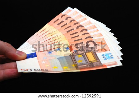 euro money in a hand on black background