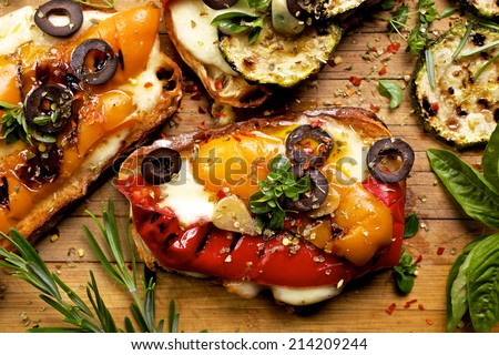 Bruschetta with grilled bell pepper, zucchini, olives and mozzarella cheese. Vegetarian dish