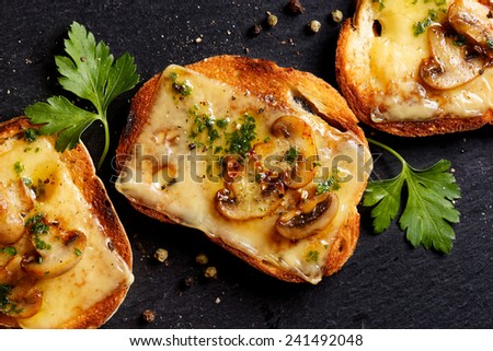 Crostini with melted cheese, mushrooms and fresh parsley
