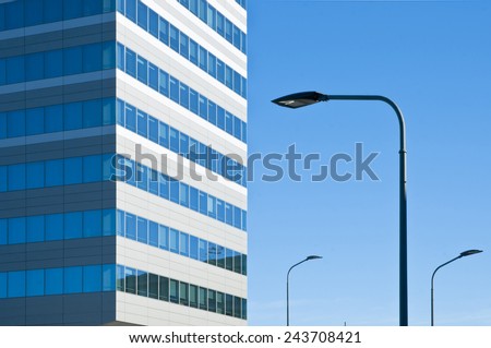 building of modern design with walls of steel and glass in the blue sky