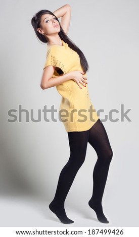 Portrait of a dancing young woman in yellow sweater. fashion concept and style. Spring clothes.