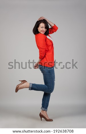 Portrait of a young woman in jeans, high heels and red jacket. Fashion shot. Modern look and style.