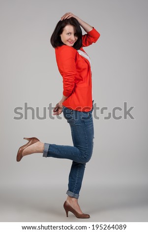 Portrait of a young woman in jeans, high heels and red jacket. Fashion shot. Modern look and style. Short hairstyle.