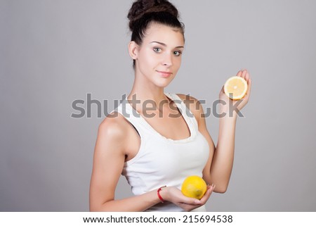 Beautiful close-up portrait of young woman with lemons. Healthy food concept. Skin care and beauty. Vitamins and minerals.