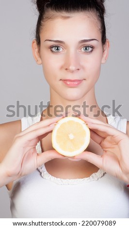 Beautiful close-up portrait of young woman with lemons. Healthy food concept. Skin care and beauty. Vitamins and minerals.