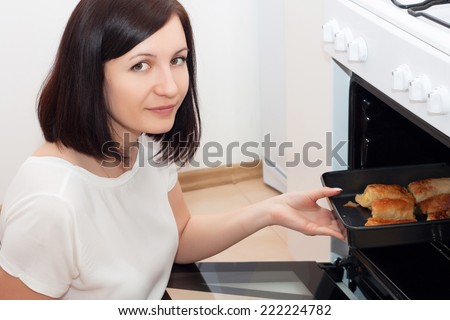 Beautiful brunette working in the kitchen. Young woman cooking in kitchen.