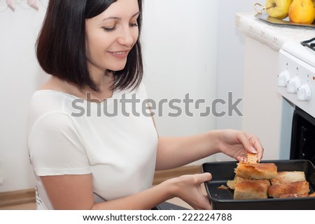 Beautiful brunette working in the kitchen. Young woman cooking in kitchen.