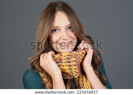 Beautiful woman with long hair wearing a sweater, scarf, hat and gloves. Holiday Fashion Portrait.
