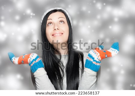 . Beautiful woman with long hair wearing a sweater, scarf, hat and gloves. Holiday Fashion Portrait.