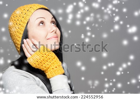 Beautiful woman with long hair wearing a sweater, scarf, hat and gloves. Holiday Fashion Portrait.