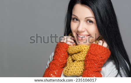 Winter Beauty Woman. Fashion Girl Concept. Skin and hair care in cold season. Portrait of a young girl with scarf, gloves and sweater.