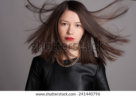 Close-up portrait of beautiful young woman with medium short hair. Fashion shot. Healthy hair concept. Studio portrait and jewelry.