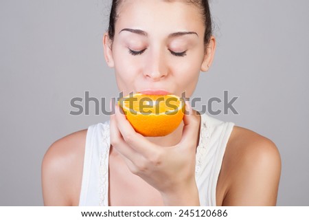 Beautiful close-up portrait of young woman with oranges. Healthy food concept. Skin care and beauty. Vitamins and minerals.